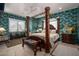 Beautiful bedroom featuring a four-poster bed, stone floors, and palm-themed wallpaper at 10567 E Mark Ln, Scottsdale, AZ 85262