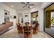 Bright breakfast nook with unique chairs, stone floors, ceiling fan, and access to an outdoor covered patio at 10567 E Mark Ln, Scottsdale, AZ 85262