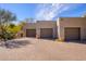 A three car garage with paver driveway and mature desert landscaping at 10567 E Mark Ln, Scottsdale, AZ 85262