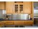 Close-up of a kitchen with stainless steel backsplash, granite countertops, and wood cabinets at 10567 E Mark Ln, Scottsdale, AZ 85262