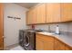 Efficient laundry room featuring modern appliances, ample counter space, and storage cabinets at 10567 E Mark Ln, Scottsdale, AZ 85262