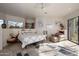 Bright main bedroom featuring a ceiling fan, sitting area, and flagstone flooring at 10567 E Mark Ln, Scottsdale, AZ 85262