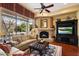 Cozy living room with fireplace and large windows overlooking backyard at 10638 E Blanche Dr, Scottsdale, AZ 85255