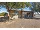 Single story house with covered patio, gravel landscaping, and mature trees at 10826 N 115Th Ave, Youngtown, AZ 85363