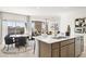 Modern kitchen island with sink and seating area overlooking living room at 15374 W Hackamore Dr, Surprise, AZ 85387