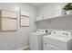 Laundry room with Whirlpool washer and dryer and shelving at 15382 W Hackamore Dr, Surprise, AZ 85387