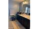 Bathroom featuring double sinks, dark cabinets, and tile floors at 16405 W Latham St, Goodyear, AZ 85338