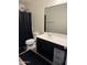 A bathroom featuring a vanity, toilet, shower with patterned curtain, and black rug at 16405 W Latham St, Goodyear, AZ 85338