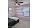 Bedroom featuring a bed with white and pink stripped accent wall at 16405 W Latham St, Goodyear, AZ 85338