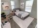 Cozy bedroom setup with a bed, desk, chair, and two windows for natural lighting at 16405 W Latham St, Goodyear, AZ 85338