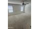 Spacious bedroom featuring neutral carpet, a ceiling fan, and natural light at 16405 W Latham St, Goodyear, AZ 85338