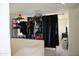 This closet is equiped with metal clothing racks and a black curtain at 16405 W Latham St, Goodyear, AZ 85338