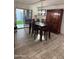 Dining room with wood-look floors, rustic wood table and decor with sliding glass patio doors at 16405 W Latham St, Goodyear, AZ 85338