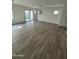 Bright living room with wood-look tile flooring and sliding doors leading to the backyard at 16405 W Latham St, Goodyear, AZ 85338