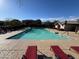 Large community pool with clear water and red lounge chairs on the deck at 16405 W Latham St, Goodyear, AZ 85338