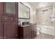 Bathroom with dark wood vanity, bathtub, and tiled walls at 17052 N 36Th Ct, Phoenix, AZ 85032