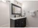 Bathroom with dark vanity, quartz countertop and modern lighting at 17052 N 36Th Ct, Phoenix, AZ 85032