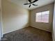 Well-lit bedroom featuring a ceiling fan and carpet at 17597 W Aster Dr, Surprise, AZ 85388