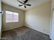 Bright bedroom with ceiling fan and carpet flooring at 17597 W Aster Dr, Surprise, AZ 85388