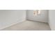 A bright bedroom with neutral carpeting, white trim and a window providing natural light at 17638 W Rancho Dr, Litchfield Park, AZ 85340
