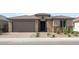 Inviting single story house featuring a covered entrance, garage, and manicured rock landscaping at 17638 W Rancho Dr, Litchfield Park, AZ 85340