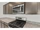 Close-up of stainless steel microwave and gas range, granite counters, and stylish cabinets at 17638 W Rancho Dr, Litchfield Park, AZ 85340