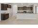 Modern kitchen with a large island, dark wood cabinets, and stainless steel appliances at 17638 W Rancho Dr, Litchfield Park, AZ 85340