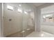 Shower featuring glass surround, a bench and modern fixtures at 17638 W Rancho Dr, Litchfield Park, AZ 85340