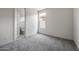 This bedroom features gray carpet, a standard window, and a door leading to the bathroom at 17644 W Rancho Dr, Litchfield Park, AZ 85340