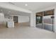 Open-concept living room featuring tile floors, gray kitchen cabinetry, and large sliding glass doors at 17644 W Rancho Dr, Litchfield Park, AZ 85340