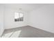 Bright and airy bedroom with grey carpet and large window at 18411 W Monte Lindo Ln, Surprise, AZ 85387