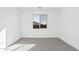 Bright and airy bedroom with grey carpet and large window at 18411 W Monte Lindo Ln, Surprise, AZ 85387