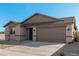 Single-story house with neutral color and attached two-car garage at 18411 W Monte Lindo Ln, Surprise, AZ 85387