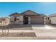 Single-story house with a two-car garage, neutral exterior, and small front yard at 18411 W Monte Lindo Ln, Surprise, AZ 85387