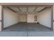 Two-car garage with an open door and concrete floor at 18411 W Monte Lindo Ln, Surprise, AZ 85387