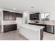 Modern kitchen with island, stainless steel appliances, and dark cabinetry at 18411 W Monte Lindo Ln, Surprise, AZ 85387