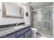 Updated bathroom with granite countertop, gray tile shower, and modern vanity at 19098 N 97Th Ln, Peoria, AZ 85382