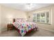 Bedroom with a queen-size bed, nightstand, and window seat at 19098 N 97Th Ln, Peoria, AZ 85382