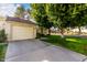 Tan colored exterior with a two car garage and mature trees at 19098 N 97Th Ln, Peoria, AZ 85382