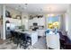 Modern kitchen with white cabinets, island, and dining area at 19350 W Clarendon Ave, Litchfield Park, AZ 85340