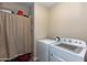 Laundry room with washer and dryer, and a curtain covering storage at 19350 W Clarendon Ave, Litchfield Park, AZ 85340