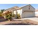 House exterior view with a two-car garage and lush landscaping at 20518 N 261St Ave, Buckeye, AZ 85396