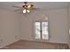 Spacious bedroom with arched window and ceiling fan at 20619 N Echo Mesa Dr, Sun City West, AZ 85375