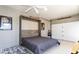 Garage bedroom showcasing a murphy bed with modern decor and ample natural light from garage door at 25046 S Foxglenn Dr, Sun Lakes, AZ 85248