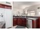 Kitchen with dark wood cabinets, granite countertops, and stainless steel appliances at 25046 S Foxglenn Dr, Sun Lakes, AZ 85248