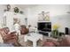 Living room with leather armchairs, a coffee table, and a large flat-screen TV at 25046 S Foxglenn Dr, Sun Lakes, AZ 85248