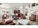 Living room with leather armchairs, a coffee table, and a large flat-screen TV at 25046 S Foxglenn Dr, Sun Lakes, AZ 85248