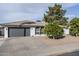 Charming single-story home featuring a well-maintained yard with mature citrus trees and a gray two-car garage at 2818 S Cottonwood Dr, Tempe, AZ 85282