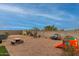 Desert landscape backyard with gravel, a picnic table, and play area at 3224 N Lainey Ln, Buckeye, AZ 85396