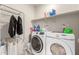 Laundry room with washer, dryer, and storage shelves at 3224 N Lainey Ln, Buckeye, AZ 85396